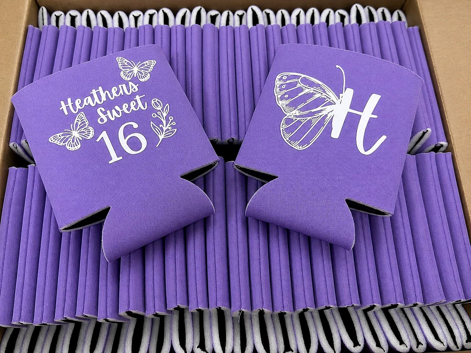 Purple custom birthday koozies arranged in a shipping box