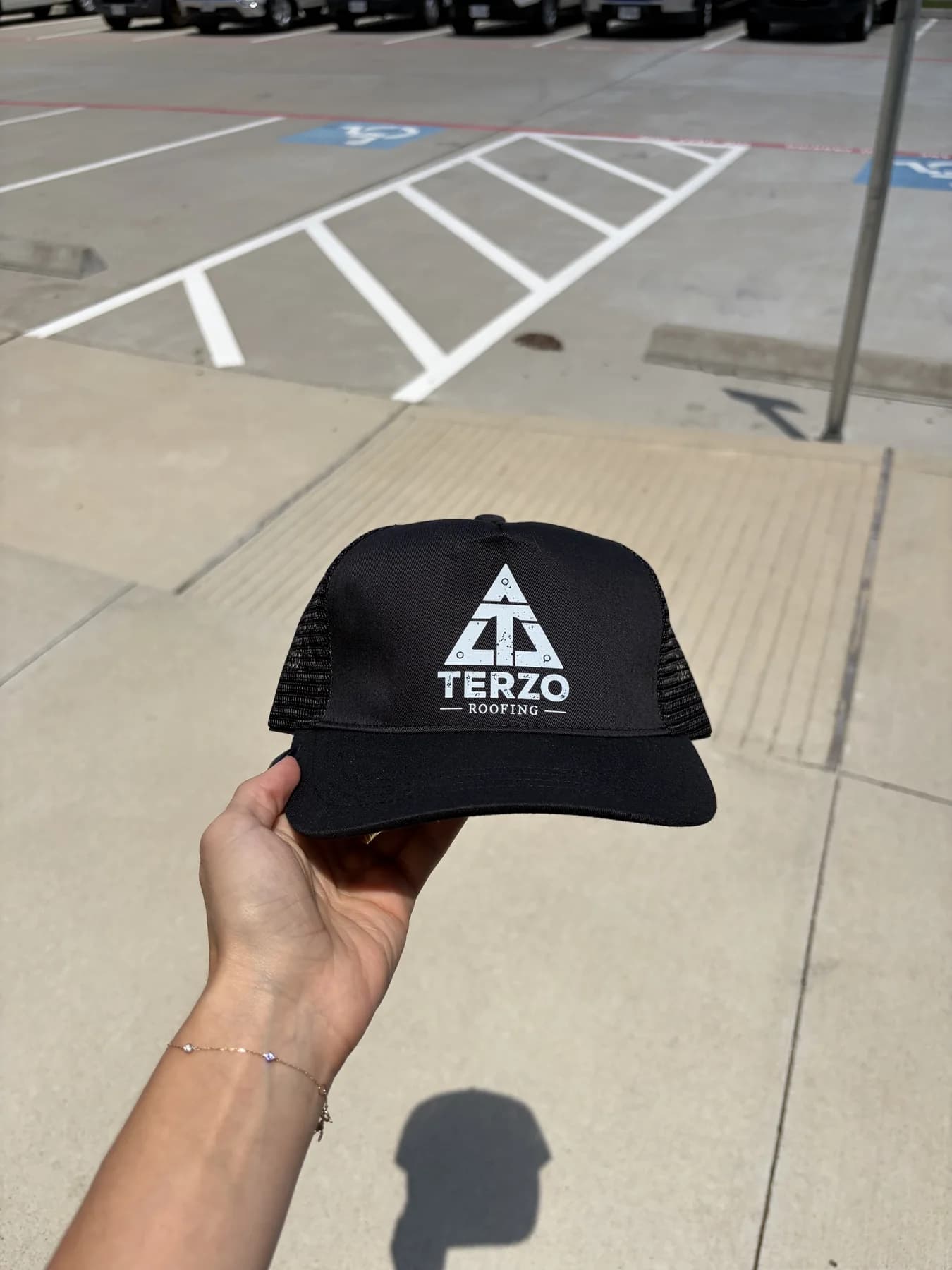 Black custom Terezo trucker hat held outdoors
